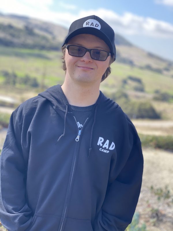A man wearing a black hoodie and hat with RAD logo