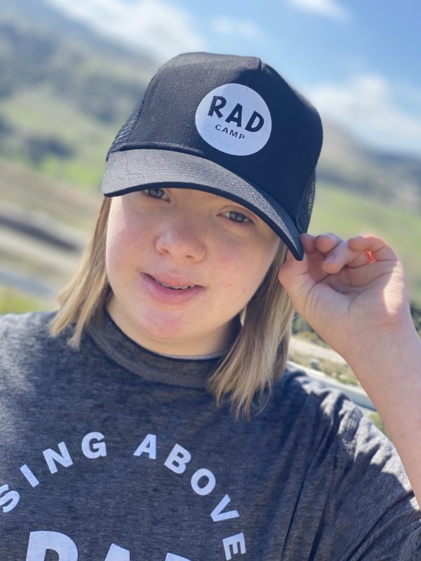 A woman wearing a black t-shirt and hat with RAD logo