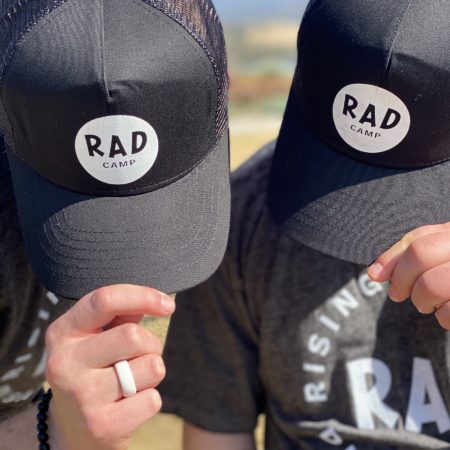 2 people tipping their RAD hats to show RAD logo
