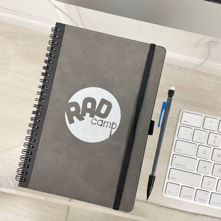 RAD notebook on desk next to computer