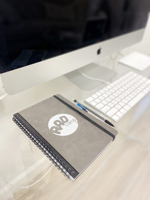 RAD notebook on desk next to computer