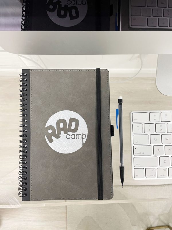 RAD notebook on desk next to computer