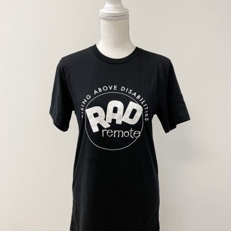 Image of the front of a black shirt on a mannequin. Shirt has the word RAD in large letters. Underneath is the word remote. RAD remote has a circle around it. The words Rising Above Disabilities is arched along the top of the circle.