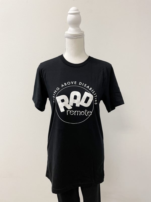 Image of the front of a black shirt on a mannequin. Shirt has the word RAD in large letters. Underneath is the word remote. RAD remote has a circle around it. The words Rising Above Disabilities is arched along the top of the circle.
