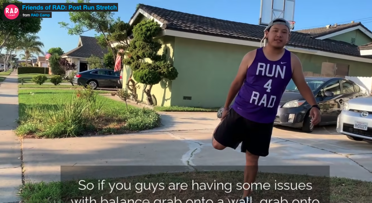 Man wearing a purple Run 4 RAD shirt doing a quad stretch